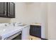 Laundry room with dark cabinets, sink, washer and dryer at 7837 Inverness Blvd, Englewood, CO 80112