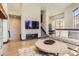 Open living room with hardwood floors, a stone fireplace, and a comfortable seating area at 7837 Inverness Blvd, Englewood, CO 80112