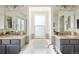 Bright bathroom featuring double sinks, a soaking tub, and neutral decor at 10109 E 28Th Ave, Denver, CO 80238