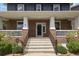 Inviting front porch with classic white columns, brick accents, and an elegant entry door at 10109 E 28Th Ave, Denver, CO 80238