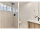 Modern bathroom with tiled walk-in shower, updated fixtures, and natural wood vanity at 2217 King St, Denver, CO 80211