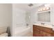 This bathroom boasts a shower and tub combination and a wood vanity at 2217 King St, Denver, CO 80211