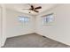 Bright bedroom with neutral carpet, white walls, and a ceiling fan with views from two windows at 2217 King St, Denver, CO 80211