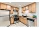 Well-lit kitchen featuring stainless steel appliances, tile flooring, and light wood cabinetry at 2217 King St, Denver, CO 80211