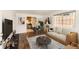 Bright living room boasts hardwood floors, a modern sofa, and an open floor plan to the dining area and kitchen at 2217 King St, Denver, CO 80211