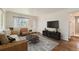 Modern living room boasts hardwood floors, an entertainment center, and a view of the entryway and bathroom at 2217 King St, Denver, CO 80211
