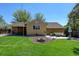 Exterior view of the home's backyard, featuring a patio, fire pit, and well-maintained lawn at 10769 Carrol Ln, Northglenn, CO 80233