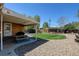 Landscaped backyard featuring a covered patio area with a picnic table, a manicured lawn, and gravel accents at 10769 Carrol Ln, Northglenn, CO 80233