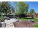 Backyard featuring a patio with seating, a stone fire pit, landscaped areas, and a wooden fence at 10769 Carrol Ln, Northglenn, CO 80233