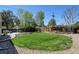 Large, well-maintained backyard featuring a lush green lawn, rock landscaping, and a patio seating area at 10769 Carrol Ln, Northglenn, CO 80233