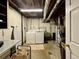Unfinished basement laundry area with washer, dryer, water heater, and functional utility sink at 10769 Carrol Ln, Northglenn, CO 80233