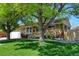 Charming brick home featuring a well-manicured lawn and mature trees providing ample shade at 10769 Carrol Ln, Northglenn, CO 80233