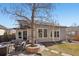 Well-maintained backyard with an outdoor seating area, built-in fire pit, mature trees, and a patio at 9805 Keenan St, Highlands Ranch, CO 80130