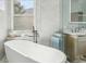 This bathroom offers a soaking tub by a window, a stylish sink, and a serene atmosphere for relaxation at 9805 Keenan St, Highlands Ranch, CO 80130
