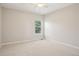 A bright, carpeted room with neutral tones and a window overlooking greenery at 9805 Keenan St, Highlands Ranch, CO 80130