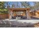 Charming gazebo with curtains, stone accents, and comfortable seating around a stone fire pit at 9805 Keenan St, Highlands Ranch, CO 80130