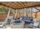 Cozy gazebo interior with stylish seating, curtains, and a unique fire pit centerpiece for outdoor enjoyment at 9805 Keenan St, Highlands Ranch, CO 80130