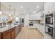 Gourmet kitchen with stainless steel appliances, white cabinets, and a spacious island with seating at 9805 Keenan St, Highlands Ranch, CO 80130