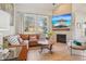 Cozy living room with a stone fireplace, large windows, and comfortable leather seating at 9805 Keenan St, Highlands Ranch, CO 80130