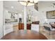 Open-concept living area with kitchen island, modern lighting, and a view of the living room with vaulted ceilings at 9805 Keenan St, Highlands Ranch, CO 80130