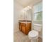 Well-lit bathroom with wood cabinets, granite countertops, and a view from the window at 10272 Greenfield Cir, Parker, CO 80134