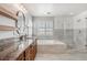 Bright primary bathroom with stone counters, a soaking tub, and a large glass shower at 10272 Greenfield Cir, Parker, CO 80134