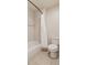 Clean bathroom featuring a shower and toilet with neutral tiling and a white shower curtain at 10272 Greenfield Cir, Parker, CO 80134