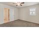 Bright bedroom with neutral carpet, a ceiling fan, and an ensuite bathroom with tiled floor at 10272 Greenfield Cir, Parker, CO 80134