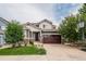 Charming two-story home with manicured lawn, mature trees, and a basketball hoop at 10272 Greenfield Cir, Parker, CO 80134