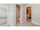 Hallway showcasing tiled floors leading to a half-bath, bedroom, and a custom closet system at 10272 Greenfield Cir, Parker, CO 80134