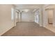Bright living room showcasing tray ceilings, carpet floors, and views to other spaces at 10272 Greenfield Cir, Parker, CO 80134