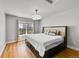 Neutral bedroom with hardwood flooring, a bed with a padded headboard, and bright window at 5906 S Youngfield Way, Littleton, CO 80127