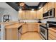 Kitchen features natural wood cabinets, stainless steel appliances, and hardwood floors at 5906 S Youngfield Way, Littleton, CO 80127
