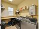 Bright laundry room featuring modern washer and dryer, utility sink, countertops, and ample storage shelving at 5906 S Youngfield Way, Littleton, CO 80127