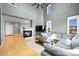 Bright living room features soaring ceilings, many windows, modern fireplace and a comfortable sectional sofa at 5906 S Youngfield Way, Littleton, CO 80127