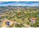 Expansive aerial view of a home situated amidst rolling hills and lush greenery, offering a serene escape at 323 Paradise Rd, Golden, CO 80401