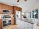 Modern kitchen featuring wooden cabinets, stainless steel appliances, a center island, and views to the dining area at 323 Paradise Rd, Golden, CO 80401