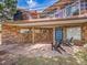 Covered patio featuring stone floors, a blue door, two Adirondack chairs, and access to the upper deck at 323 Paradise Rd, Golden, CO 80401