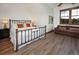 Bright bedroom with a wrought iron bed frame, hardwood floors, and a cozy sitting area at 34 Highfield Trl # 311, Breckenridge, CO 80424