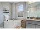 Relaxing bathroom featuring a soaking tub, window, and modern fixtures at 12917 Fox St, Westminster, CO 80234
