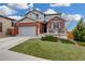 Beautiful home features a brick and gray exterior, two-car garage, with a well-maintained lawn at 12917 Fox St, Westminster, CO 80234