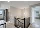 Upper hallway with decorative brick wall, modern light fixture, and open flow to rooms at 12917 Fox St, Westminster, CO 80234