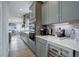 Modern kitchen featuring gray cabinets, quartz countertops, stainless steel appliances, and a built-in wine fridge at 12917 Fox St, Westminster, CO 80234