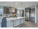Modern kitchen with gray cabinets, quartz countertops, stainless steel appliances, and an island with bar stool seating at 12917 Fox St, Westminster, CO 80234