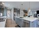Open-concept kitchen featuring gray cabinets, quartz countertops, stainless steel appliances, and a view of the staircase at 12917 Fox St, Westminster, CO 80234