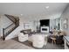 Spacious living room featuring an elegant fireplace, plush seating, and a staircase, perfect for relaxation at 12917 Fox St, Westminster, CO 80234