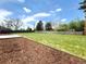 Spacious backyard with green grass, a stone patio, and mulched area, offering versatile outdoor possibilities at 375 Kendall St, Lakewood, CO 80226