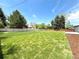 Expansive, newly-landscaped backyard featuring lush lawn, privacy fence, and mature trees at 375 Kendall St, Lakewood, CO 80226