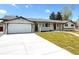 Charming single-story home featuring a well-manicured lawn, long driveway, and two-car garage at 375 Kendall St, Lakewood, CO 80226