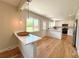 Modern kitchen with white cabinets, a breakfast bar, and a bright window overlooking the backyard at 375 Kendall St, Lakewood, CO 80226